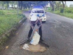 Tutupi Lubang Jalan Berlubang Area Suramadu, Anggota Satlantas Polres Bangkalan Antisipasi Kecelakaan